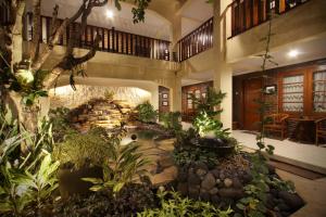 a large indoor garden with a pond in a building at De Hostel Yogyakarta in Yogyakarta