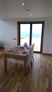 a dining room with a table and a view of the beach at An Taigh Mòr in Eriskay