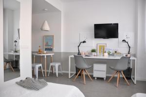 a room with chairs and a table with a tv on the wall at Residencia Universitaria Tarragona Mediterrani in Tarragona