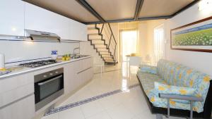 a kitchen and living room with a couch and a stove at Gardenia in Amalfi