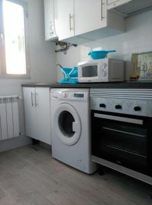 a kitchen with a washing machine and a microwave at Apartamento Carabanchel Castizo in Madrid