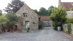 an old stone house with a gravel driveway at Bishops Farm in Thornbury
