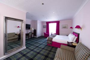 a hotel room with a bed and a mirror at The Royal George Hotel in Perth