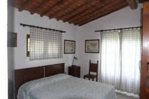 a bedroom with a bed and two windows at Casa Vacanze Good Buy in San Gimignano +16 photos