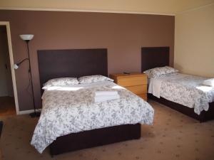 um quarto de hotel com duas camas e um candeeiro em Kingswood Hotel em Maidenhead