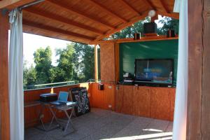 a screened in porch with a tv and a table with a laptop at Casa Vacanze Good Buy in San Gimignano