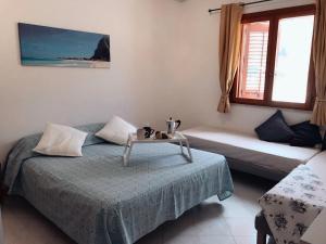 a bedroom with a bed and a table and a window at Casa MareLuna in San Vito lo Capo