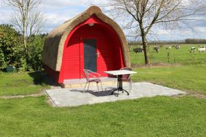 Drijber的住宿－波德露營地，红色小屋前的桌椅