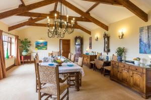 a dining room with a table and chairs and a kitchen at Ael y Bryn Luxury B&B, North Pembrokeshire in Eglwyswrw