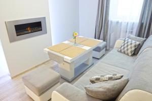 ein Wohnzimmer mit einem Sofa und einem Tisch in der Unterkunft Apartament Kłos in Wisła