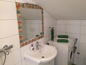 a bathroom with a sink and a toilet and a mirror at Apartments Brčić in Kaštela +53 photos