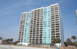 a tall building with blue windows on the beach at Club Regency at Regency Towers in Myrtle Beach
