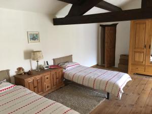 a bedroom with two beds and a table with a lamp at 17 St Romain in Saulgond