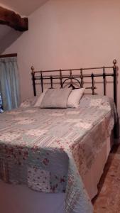 a bedroom with a bed with a floral bedspread at 17 St Romain in Saulgond