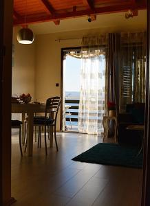 sala de estar con mesa, sillas y ventana en Cosy Sunset Apartment en Omiš