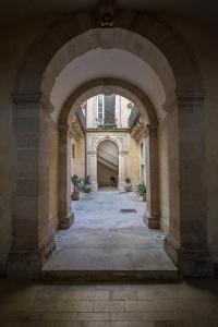 シラクーサにあるLoft La Casetta Ortigiaの鉢植えの古い建物のアーチ道