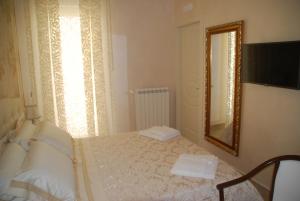1 dormitorio con cama y espejo en Daphnae House, en Palma di Montechiaro