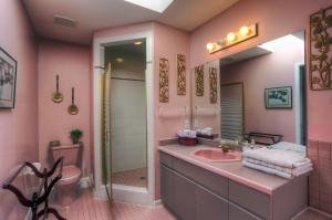 a pink bathroom with a sink and a shower at Beds By the Bridge in Kelowna +39 photos