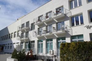 a white building with balconies on the side of it at Apartamenty Międzyzdroje in Międzyzdroje