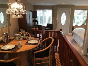 a dining room with a table and a bed at Corbett Guest Suites in Sidney