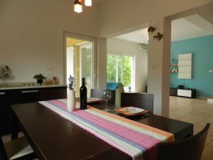 a dining room with a table with a bottle of wine at Dee's House and Pool in Labin