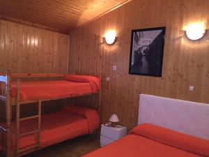 1 dormitorio con 2 literas con sábanas rojas en Bungalows & Albergue La Playa, en Logroño 37 fotos más