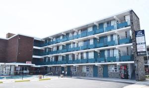 un edificio de apartamentos con balcones azules y aparcamiento en Skyview Manor Motel en Seaside Heights