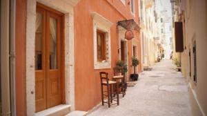 un callejón con sillas y mesas en una calle en Locandiera, en Corfú