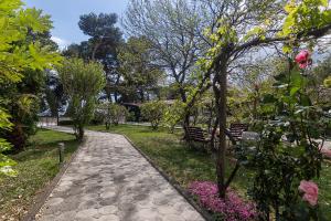 un camino en un parque con flores y árboles en Apartments Villa Mili en Brela