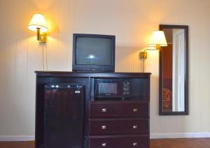 TV en la parte superior de un tocador con microondas en Skyview Manor Motel en Seaside Heights