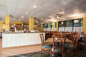 a restaurant with tables and chairs and a bar at Grande Shores in Myrtle Beach