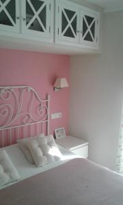 sypialnia z łóżkiem i różową ścianą w obiekcie Exclusive Views Ronda w mieście Ronda