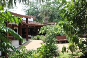 a house with a patio and trees at La Quinta Sarapiqui Lodge in Sarapiquí