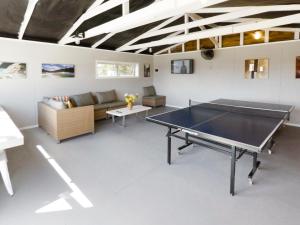 a living room with a ping pong table in it at Cosy Cottage Thermal Holiday Park in Rotorua