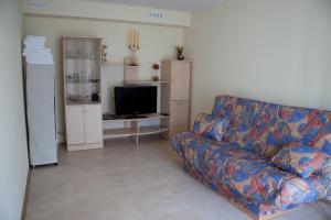 a living room with a couch and a flat screen tv at PribaltDom in Jūrmala