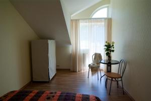 a room with a table and chairs and a window at PribaltDom in Jūrmala