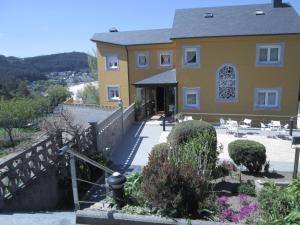 ein gelbes Haus mit einer Treppe, die hinaufführt in der Unterkunft Complexo Alameda in Viveiro