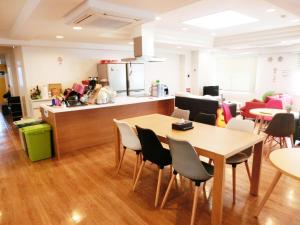 a restaurant with tables and chairs and a kitchen at Guesthouse TOHO in Nagoya