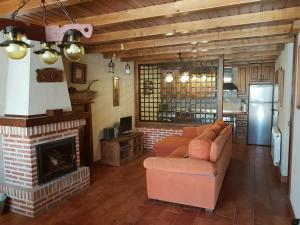 sala de estar con sofá y chimenea en Casa Rural El Castaño en Navalguijo