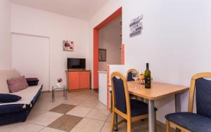 a living room with a table and a couch at Apartments Kraljić in Baška