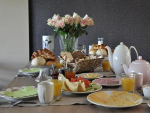 a table topped with plates of food and drinks at Bed & Breakfast Langlaar in Nuenen