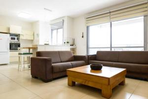 een woonkamer met 2 banken en een salontafel bij Kfar Saba Center Apartment in Kefar Sava