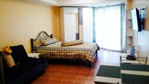 a bedroom with a bed and a chair and a couch at Jomtien beach Condominium S2 in Jomtien Beach +23 photos