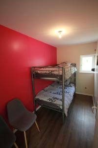 イラウーゼルヌにあるLes Bords de L´Illの赤い壁の客室で、二段ベッド2組が備わります。