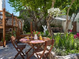 a wooden table and chairs in a garden at Helios Garden Boutique Apartments in Rhodes Town