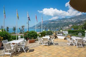 un grupo de mesas y sillas en un patio en Hotel Pietra di Luna, en Maiori