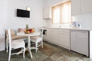 a kitchen with a table with a bowl of fruit on it at Ambelas Mare Apartments in Ambelas