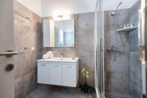 a bathroom with a white sink and a shower at Ambelas Mare Apartments in Ambelas