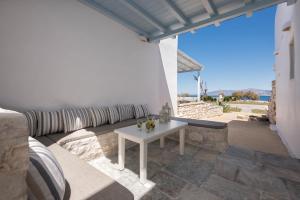 a white table on a patio with a white couch at Ambelas Mare Apartments in Ambelas