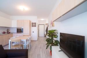 een keuken en eetkamer met een tafel en een tv bij Appartamento Molo B in Portoferraio